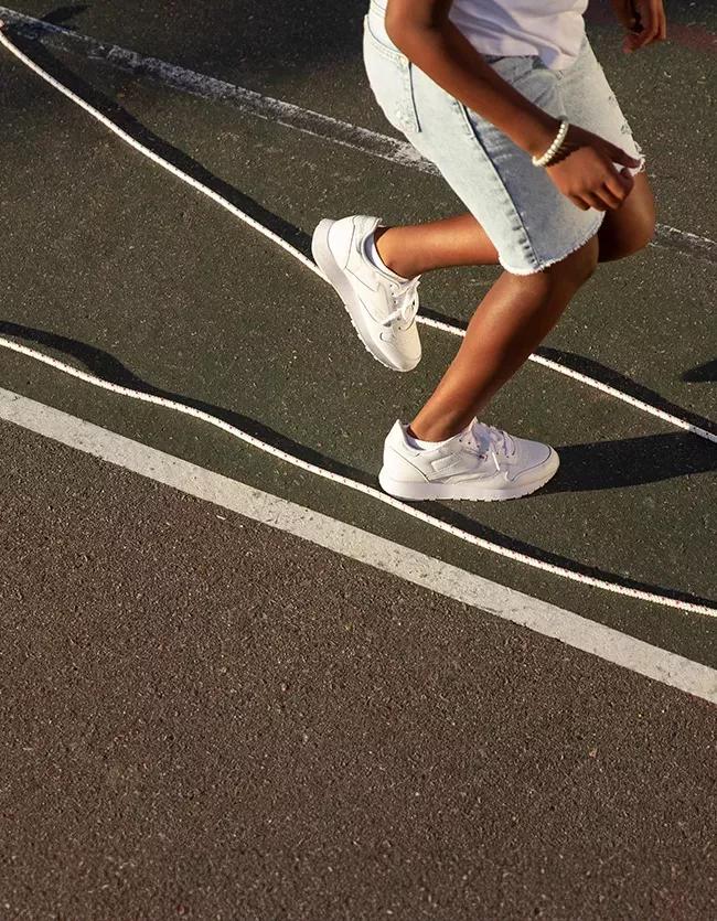 Foto Stock Soccer, girl and black woman with shoes to start playing a  football game for cardio exercise, workout and training. Sports, fitness  and healthy athlete exercising ties boots on grass in